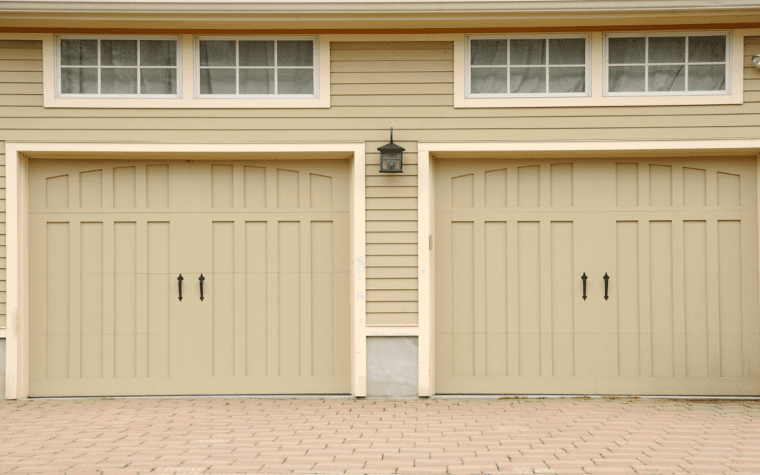 Two tan garage doors featuring garage door hardware