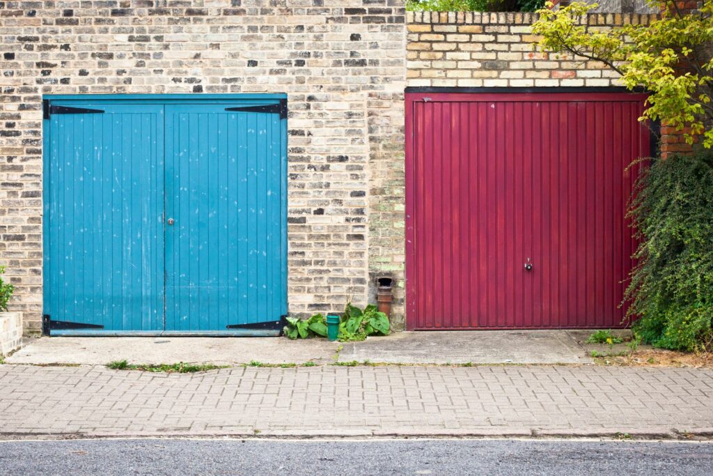 Two different garage door designs, one red, one blue